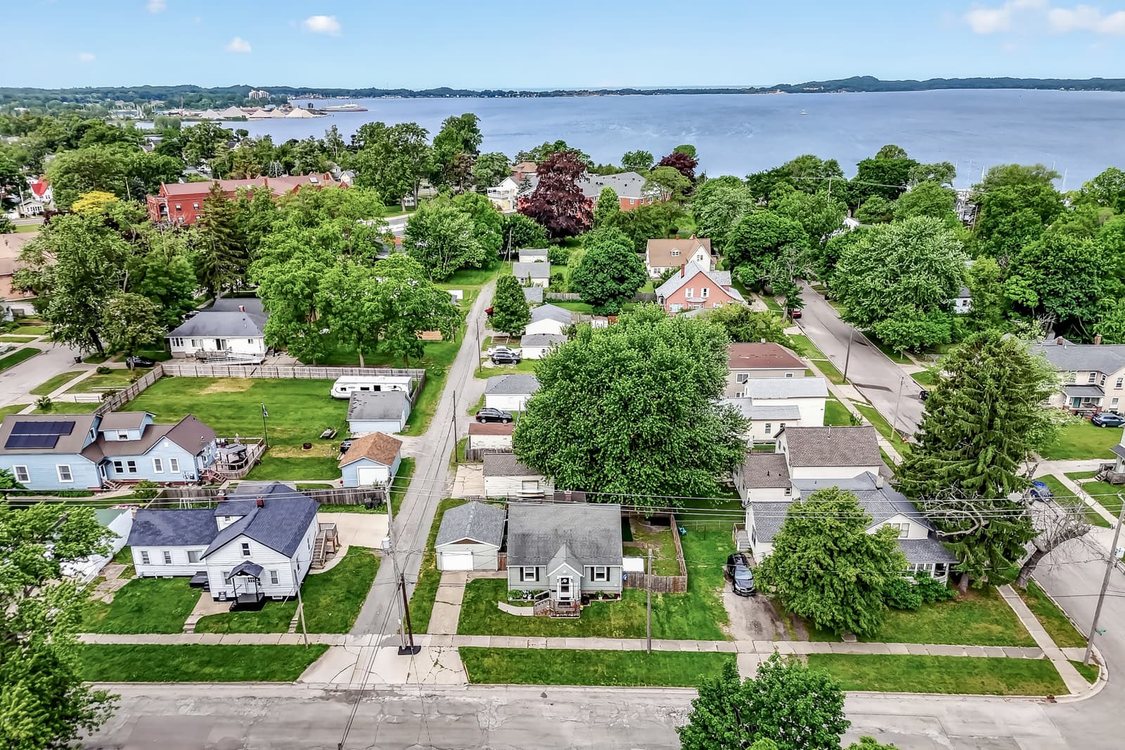 Aerial view of a Muskegon neighborhood with Muskegon Lake beyond the rooftops